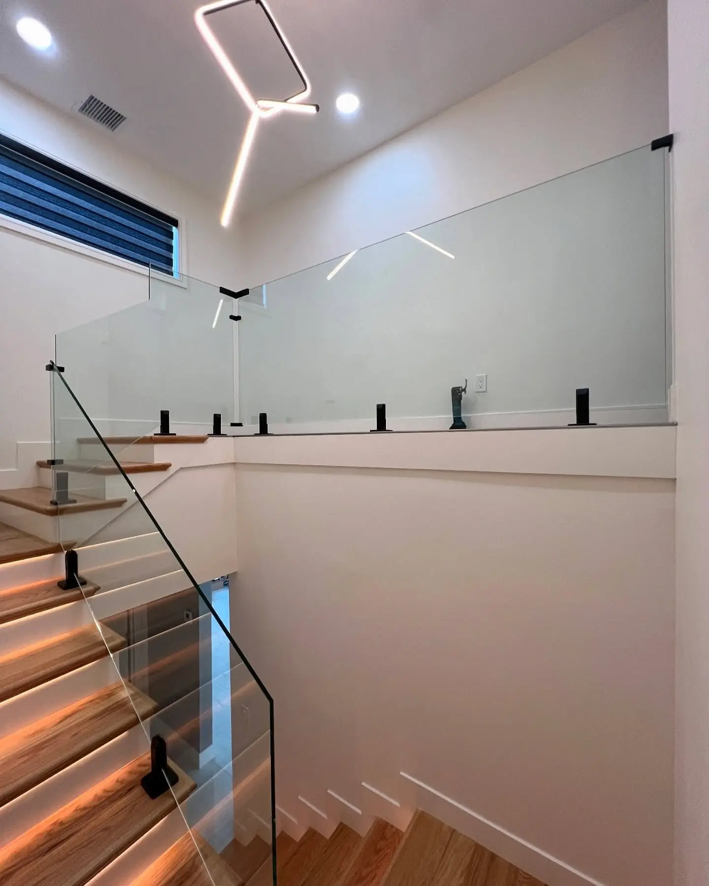 Frameless glass stair railing mounted with standoff hardware